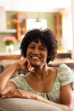 Young biracial woman smiles warmly at home, with copy space unaltered
