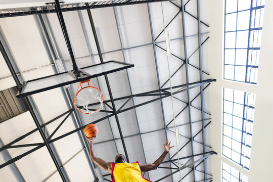 African American man scores a basket in an indoor gym