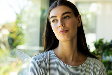 Teenage Caucasian girl looks contemplative by a window