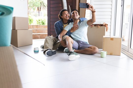 Diverse gay couple takes a selfie at home