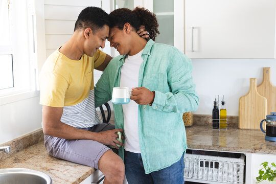 Biracial gay couple enjoys a cozy moment in the kitchen - Powered by Adobe