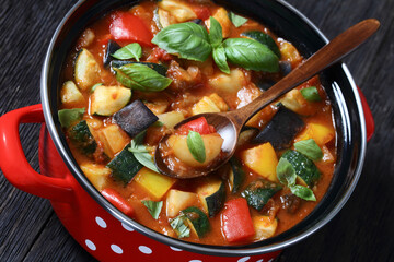 hearty italian vegetable stew in red pot, top view