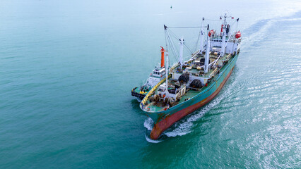 Fototapeta premium Cargo Ship was pulling by Tugboat go to Maintenance port. cargo ship import export to customers sea port. export shipping industry freight and transportation logistics concept..