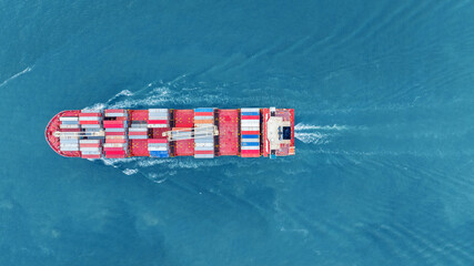 Fototapeta premium Cargo container ship carrying container and running in the ocean near international container port customs shipyard sea port concept smart logistic service. transportation logistics trading..