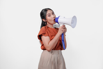 Lively young Asian woman shouting at megaphone as if the woman is performing or giving a speech.