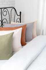 White Bed With Green Striped Pillow and Ornate Black Headboard