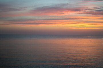 lonely fisherman on a boat at sunset