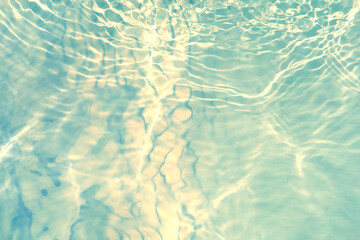 Blue water with ripples on the surface. Defocus blurred transparent blue colored clear calm water surface texture with splashes and bubbles. Water waves with shining pattern texture background.