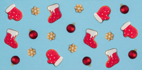 Christmas gingerbread in the shape of a mitten and a felt boot on the blue background. Pattern....