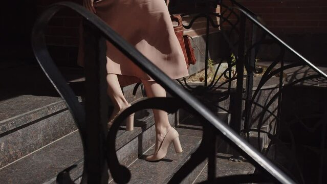 Women's legs in heels climbing the stairs, side view