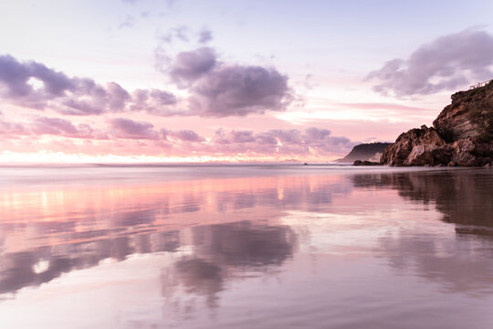 Pastel pink sunset at beach reflecting off sand, Gold Coast