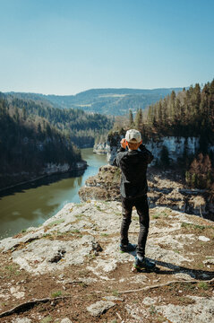 Boy hiking, watching River Doubs, Switzerland, from a cliff viewpoint