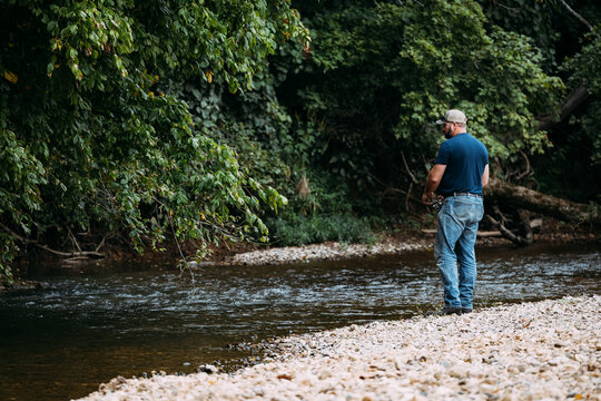 Man fishing from riverbank at Castor River in summer