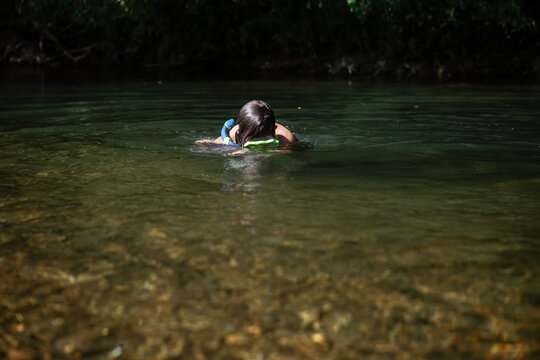 Child snorkeling in shallow river