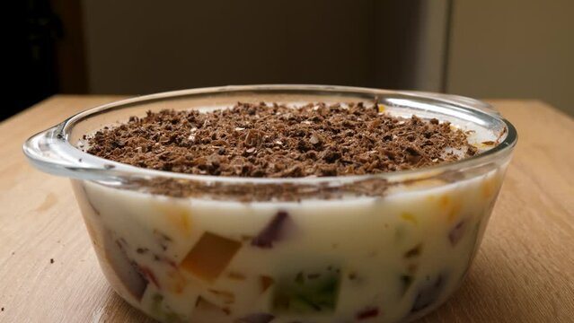 Chocolate shavings are added to the hardened dessert jelly. Preparation of gelatin desserts.