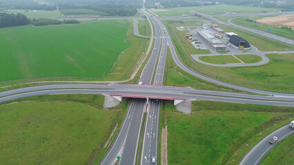 Drone shot of countryside road junction and green landscape