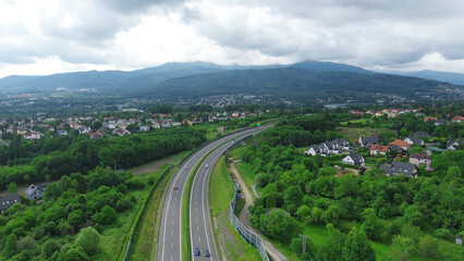 Obraz premium Elevated highway passing through rural area with houses and trees