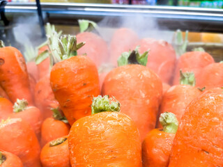 Carrot in a grocery store. Vegetable displayed in the shop. Sprayed to keep it fresh. Eco-friendly product.