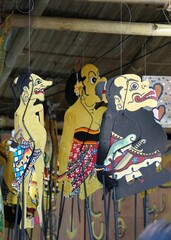 Decorative ornaments featuring several shadow puppets (wayang kulit) hanging by strings.