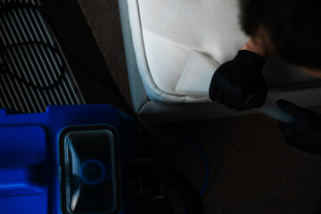 Cleaner is using extractor machine to clean the bed mattress in the house. Absorbing the dirt from...