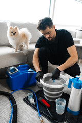 Cleaning fur from carpets and furniture at home using extractor. Cleaner is preparing detergent for...