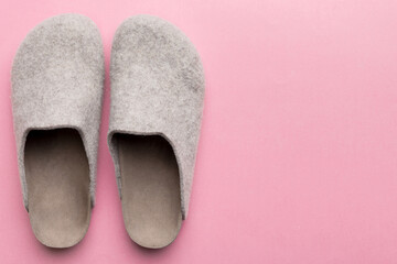 Warm winter women woolen slippers on colored background. Copy space for text