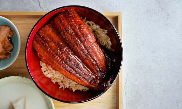 Unadon, charcoal grilled freshwater eel Unagi kabayaki with teriyaki sauce over rice, traditional Japanese cuisine, Rice topped with broiled eel in wood urushi lacquerware