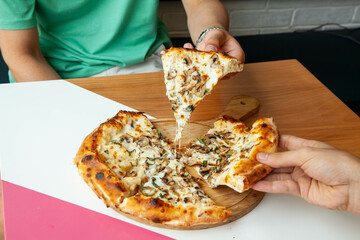 Italian authentic naples pizza four cheese and all vegetable and mushrooms, eating at a restaurant.