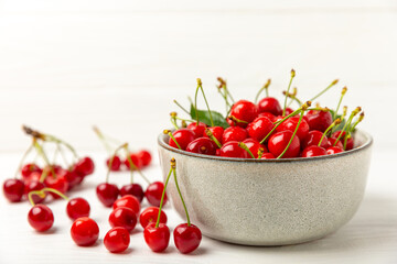 Cherries. Fresh ripe cherries with leaves on a textured wooden background. Fresh sweet organic cherry pile. Berries and fruits. Vegan. Healthy eating. Place for text. Copy space