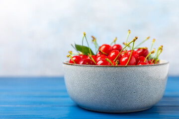 Cherries. Fresh ripe cherries with leaves on a textured wooden background. Fresh sweet organic cherry pile. Berries and fruits. Vegan. Healthy eating. Place for text. Copy space