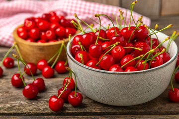 Cherries. Fresh ripe cherries with leaves on a textured wooden background. Fresh sweet organic cherry pile. Berries and fruits. Vegan. Healthy eating. Place for text. Copy space