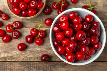 Cherries. Fresh ripe cherries with leaves on a textured wooden background. Fresh sweet organic cherry pile. Berries and fruits. Vegan. Healthy eating. Place for text. Copy space