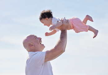 Happy grandfather, baby and air with blue sky for bonding, holiday or outdoor weekend together in nature. Grandpa holding or lifting child, kid or infant in embrace for vacation, love or support