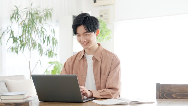 自宅でノートパソコンを使う男性	