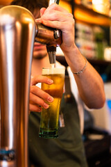 Bartender making a beer in the restaurant's pump. Vertical