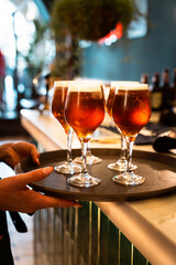 Hands of a woman waitress placing the beers on the tray before serving them. Vertical