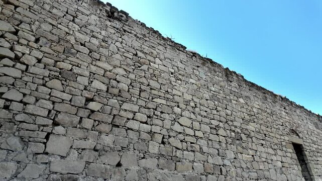 A low angle view of the stone walls of the Genoese Fortress in Feodosia, Russia. The fortress is a popular tourist destination and a reminder of the city's rich history.