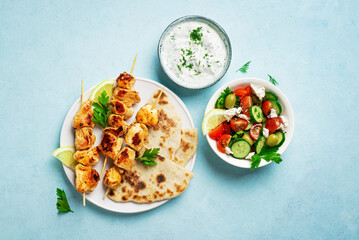 Chicken souvlaki kebabs with flatbread and greek salad