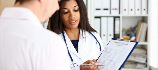 Female doctor hand hold silver pen and showing pad. Physical agreement form signature disease...