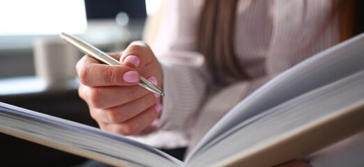 Female clerk arm make marks in notepad with silver pen closeup at office workplace. Audit paperwork financial inspector assistant fill survey form for job offer management training course discussion
