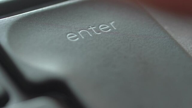 Extreme closeup shot of finger pressing the enter button on keyboard