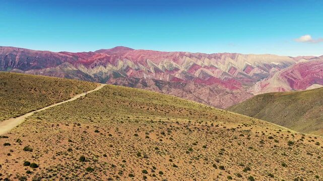Aerial dolly shot over tourists looking at the vibrant hillside of El Hornocal