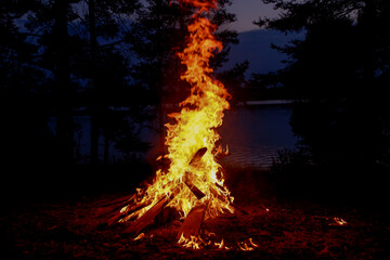 A grand bonfire blazes in the darkness, illuminating the surroundings