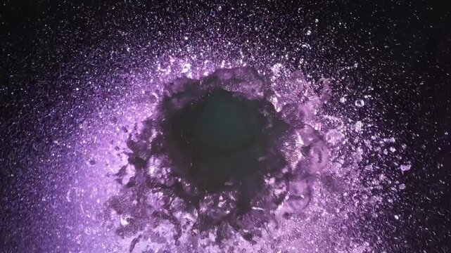 Top close shot of purple color fountain flowing, water sprinkling around