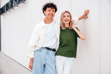 Fototapeta premium Smiling beautiful woman and her handsome boyfriend. Couple in casual summer clothes. Happy cheerful family. Female and man having fun. They posing in the street in sunny day. Having tender moments