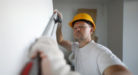 Male inspector in protective gloves hold building level in hand portrait. Checks the quality of...