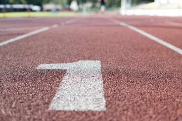 Numer jeden. Bieżnia lekkoatletyczna na stadionie. Zawody sportowe, olimpiada.