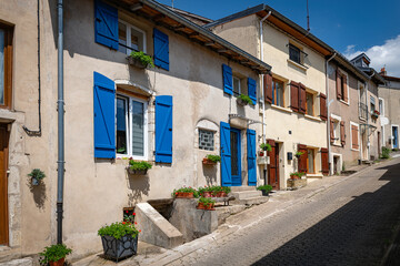 Fototapeta premium a stylish street with old houses with shuttered windows and blue and brown in France