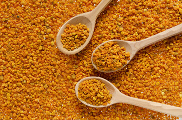 Three wooden spoons with bee pollen, top view