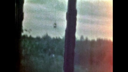 Old rural window view in green forest. Lonely, quiet lifestyle inside village house. No people. Country home surrounded by summer nature. Vintage color film. Family archive. Retro 1960s countryside